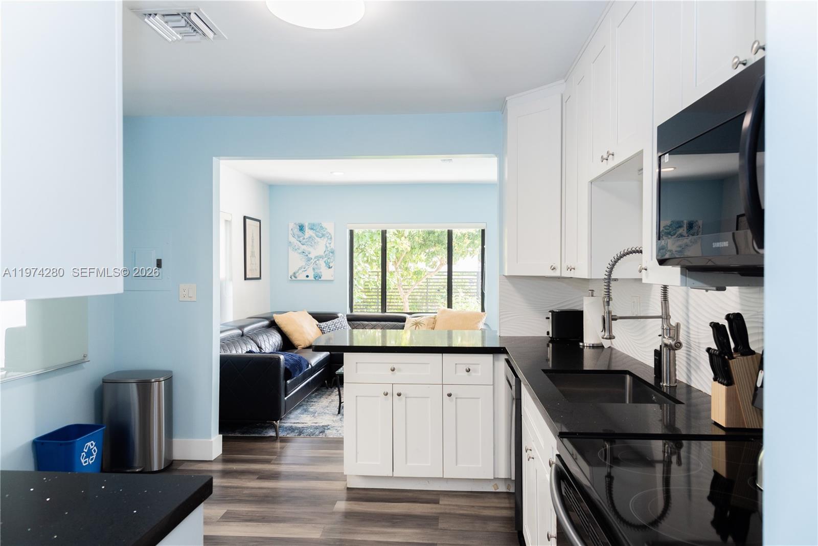 3134 Carter Street Miami, FL 33133 - Photo 31 of 36 a kitchen with granite countertop a sink appliances cabinets and a counter top space