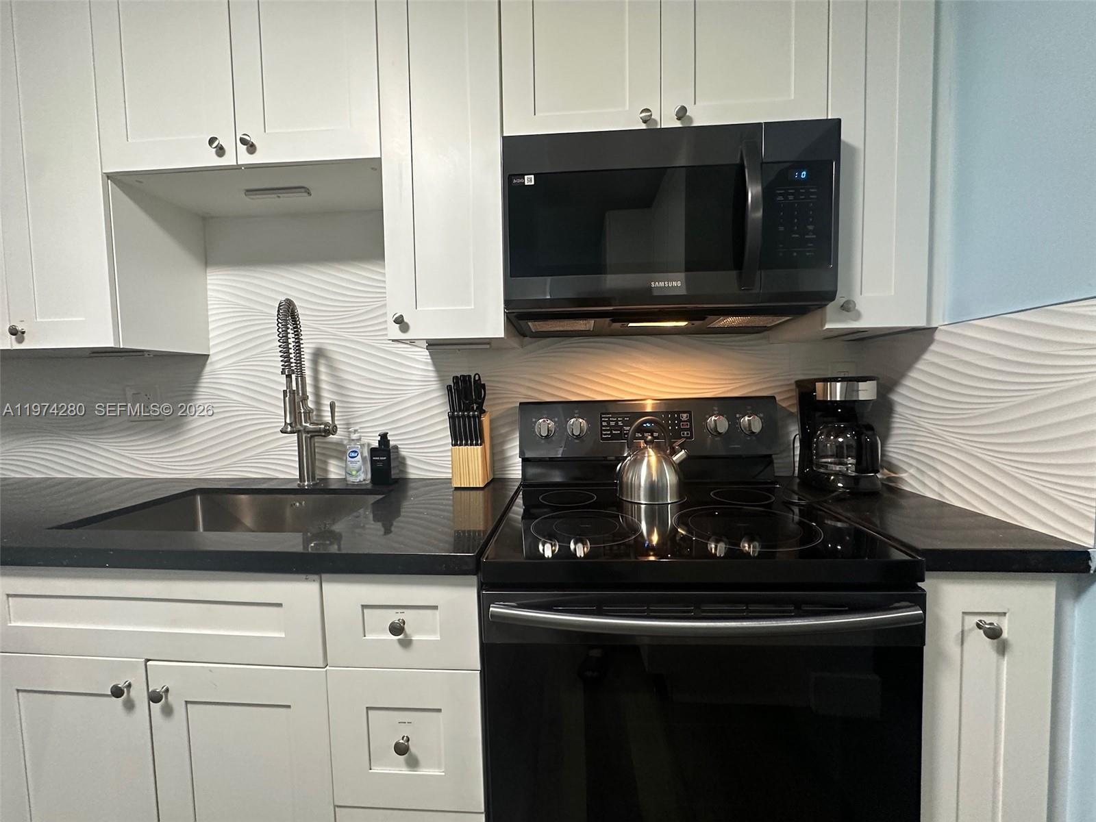 3134 Carter Street Miami, FL 33133 - Photo 5 of 36 a kitchen with a stove and a microwave