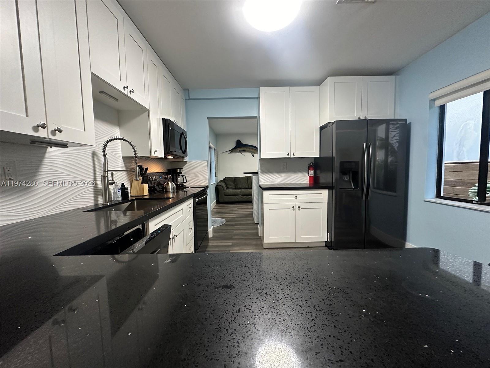3134 Carter Street Miami, FL 33133 - Photo 8 of 36 a kitchen with a refrigerator and a stove top oven