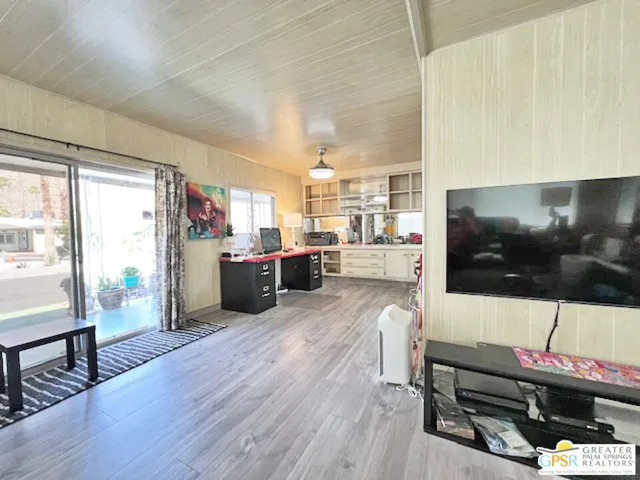 a living room with stainless steel appliances furniture and a flat screen tv