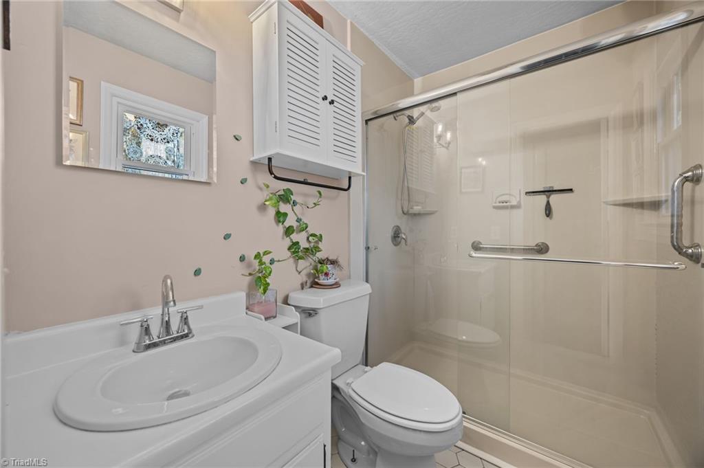 931 Ransom Road Winston-Salem, NC 27106 - Photo 5 of 48 Ensuite primary bathroom with single vanity and standalone shower.