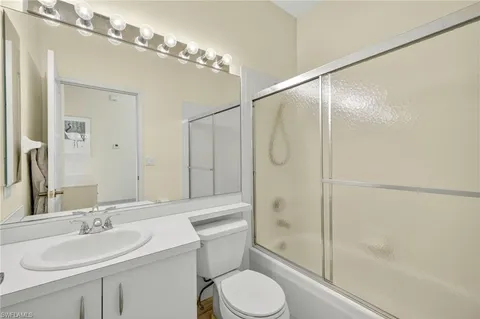 a bathroom with a sink toilet vanity and shower
