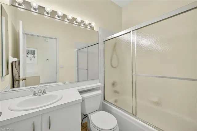 a bathroom with a sink toilet vanity and shower