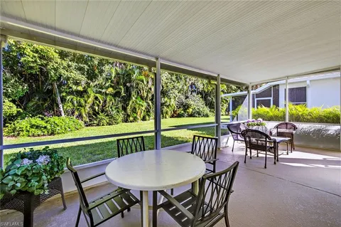 a view of a patio with a table chairs and a backyard