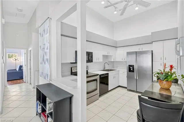 a kitchen with white cabinets and stainless steel appliances