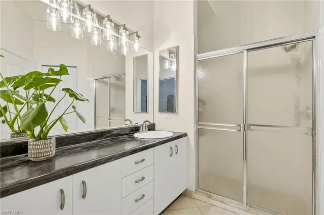 a bathroom with a granite countertop sink a mirror and a shower