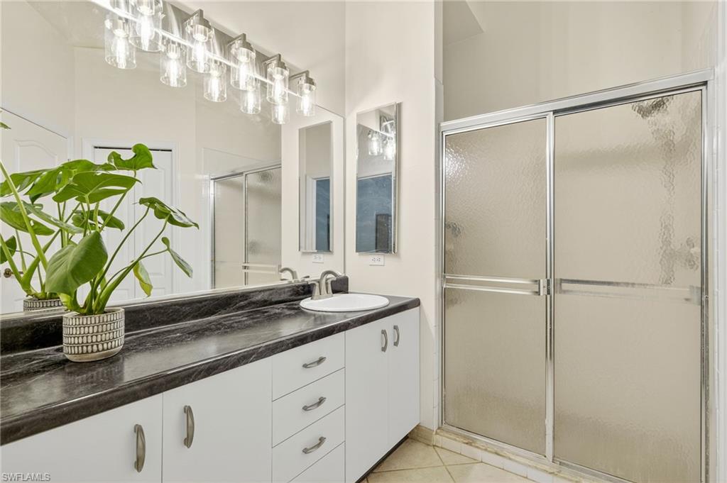 20818 Blacksmith Estero, FL 33928 - Photo 7 of 21 a bathroom with a granite countertop sink a mirror and a shower