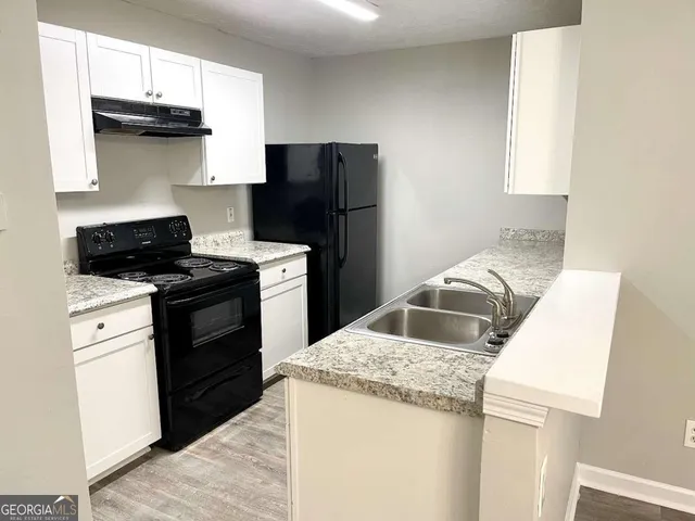 a kitchen with a stove a sink and a refrigerator