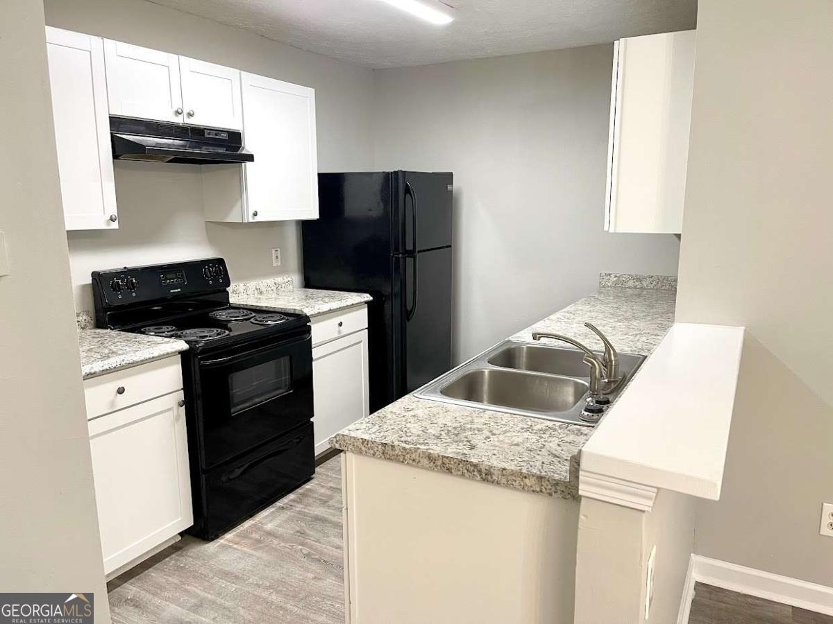 5594 Fair Creek Way Lithonia, GA 30038 - Photo 4 of 15 a kitchen with a stove a sink and a refrigerator