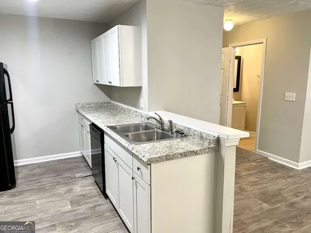a kitchen with a granite countertop sink and washing machine