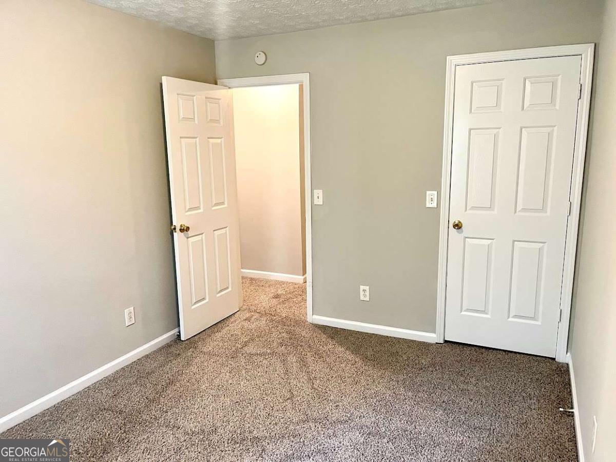 5594 Fair Creek Way Lithonia, GA 30038 - Photo 10 of 15 an empty room with windows and closet