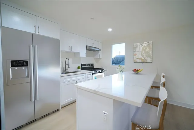 a kitchen with refrigerator and white cabinets