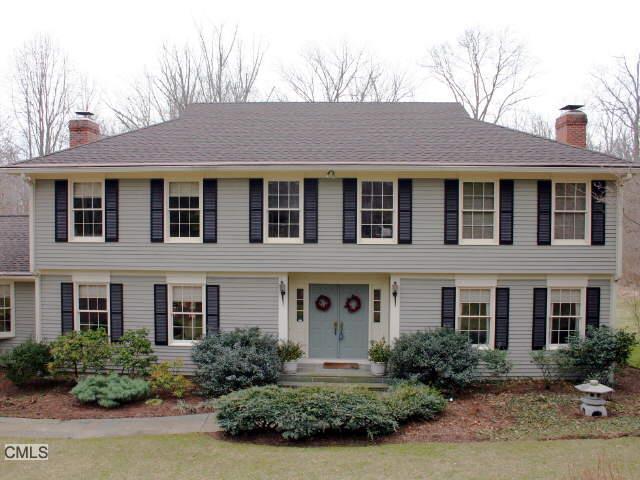a front view of a house with garden and plants