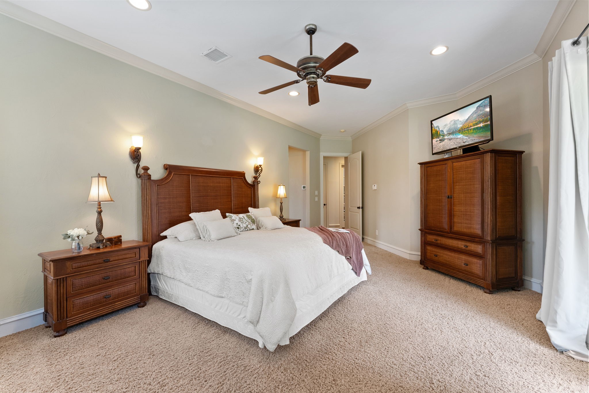 3907 Rayford Road Spring, TX 77386 - Photo 16 of 38 The spacious Primary Suite features crown molding, a ceiling fan, sconce lighting, and large windows positioned to take in views of the stunning backyard.
