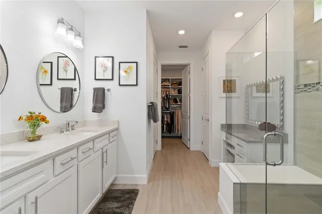 a bathroom with a granite countertop sink a mirror a toilet and a shower