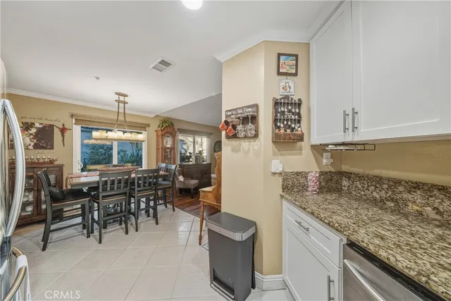 a kitchen with granite countertop a table and chairs in it