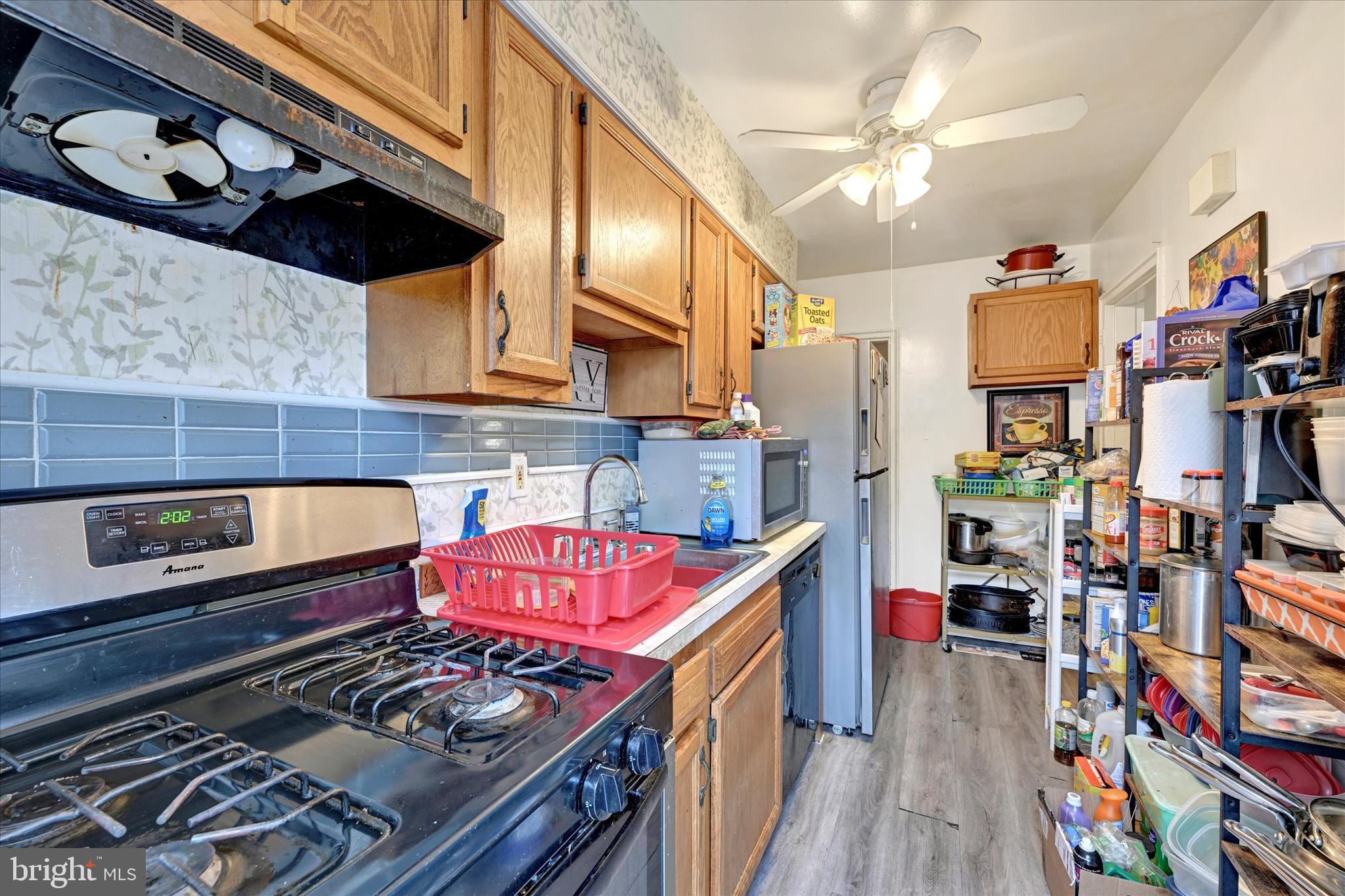 517 Random Road Baltimore, MD 21229 - Photo 5 of 13 a kitchen with stainless steel appliances granite countertop a stove and cabinets