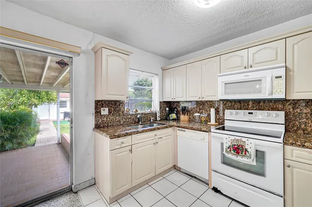 a kitchen with white cabinets and white appliances