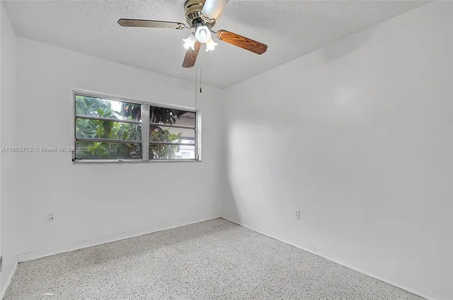 en empty room with window and ceiling fan