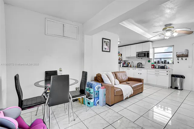 a kitchen with white cabinets and sink