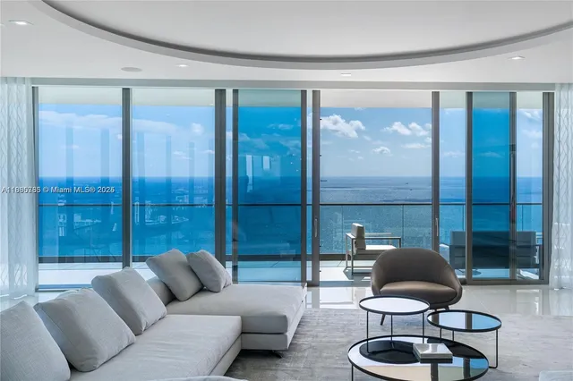 a living room with furniture and a floor to ceiling window