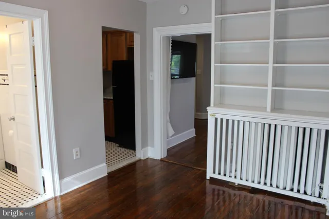 a view of a hallway with wooden floor and a window