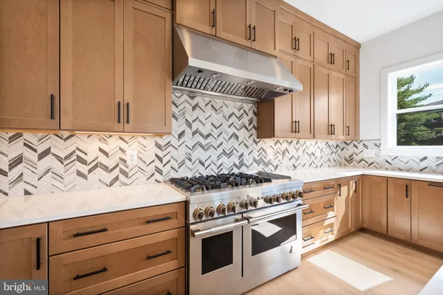 an empty room with wooden floor and a ceiling fan