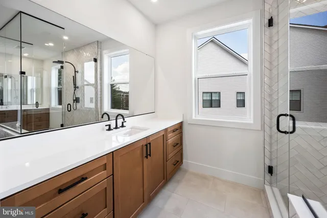 a bathroom with a tub sink double vanity and shower