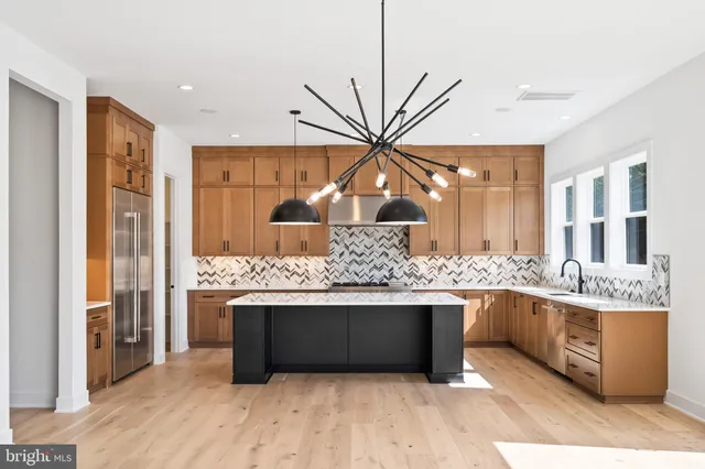 a kitchen with stainless steel appliances granite countertop a stove a sink and a wooden floors