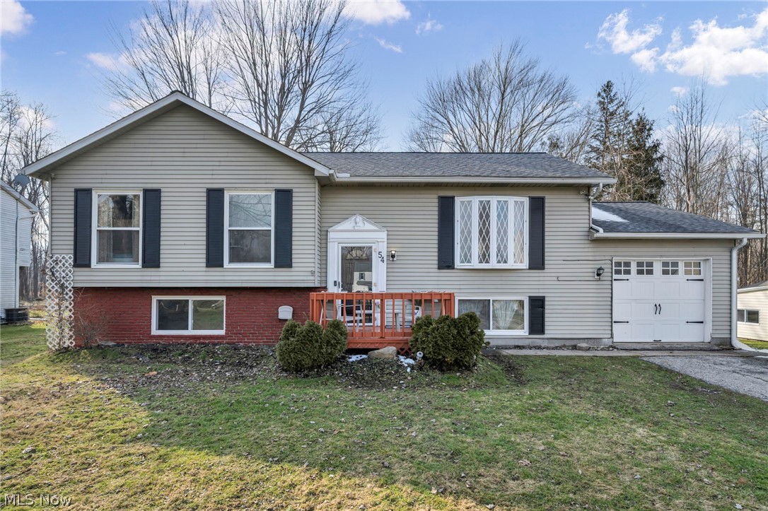 54 Park Road Painesville, OH 44077 - Photo 3 of 38 Raised ranch with a front lawn, a garage, a shingled roof, and driveway
