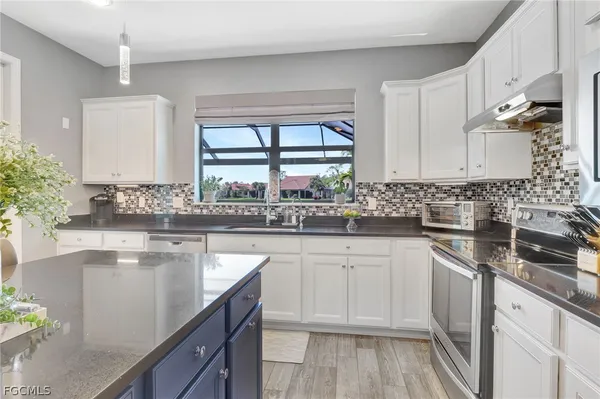 a kitchen with stainless steel appliances granite countertop a sink stove and cabinets