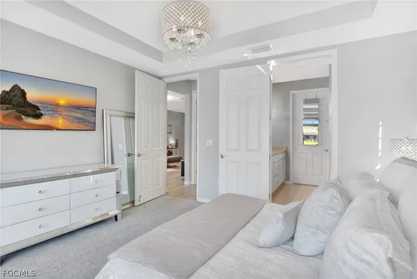 a spacious bedroom with a bed and a chandelier