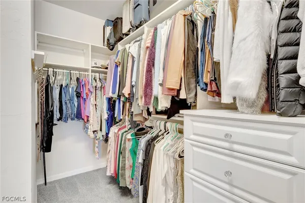 a view of walk in closet with clothes and shoes