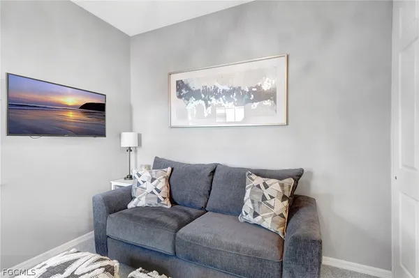 a living room with furniture and a view of kitchen