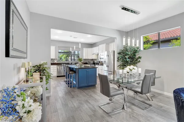 a living room with furniture potted plant and kitchen view