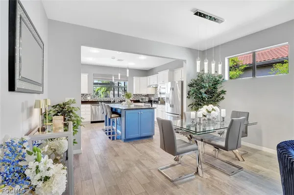 a living room with furniture potted plant and kitchen view