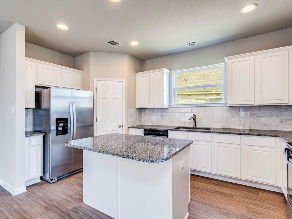 4210 Birdwatch Loop, Unit 2 Pflugerville, TX 78660 - Photo 12 of 31 A well-appointed kitchen features a central island, ample cabinetry, and sleek stainless steel appliances.