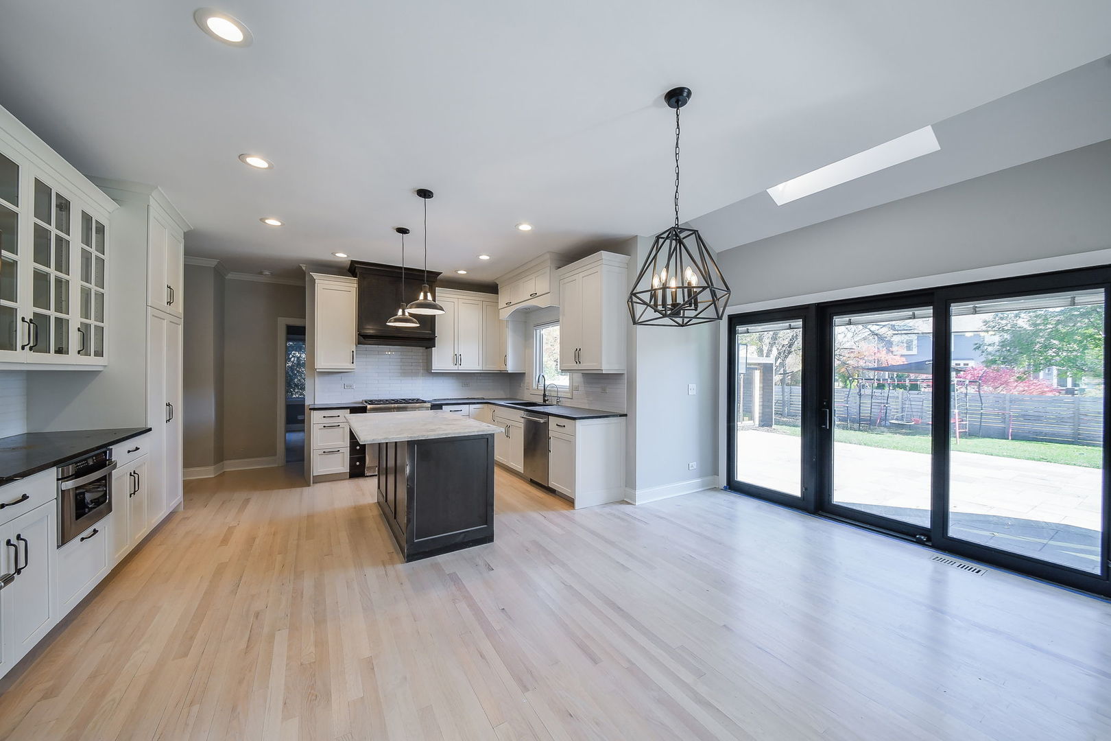 24 Winners Cup Circle Wheaton, IL 60189 - Photo 7 of 46 a open kitchen with stainless steel appliances granite countertop a stove top oven a sink dishwasher a dining table and chairs with wooden floor