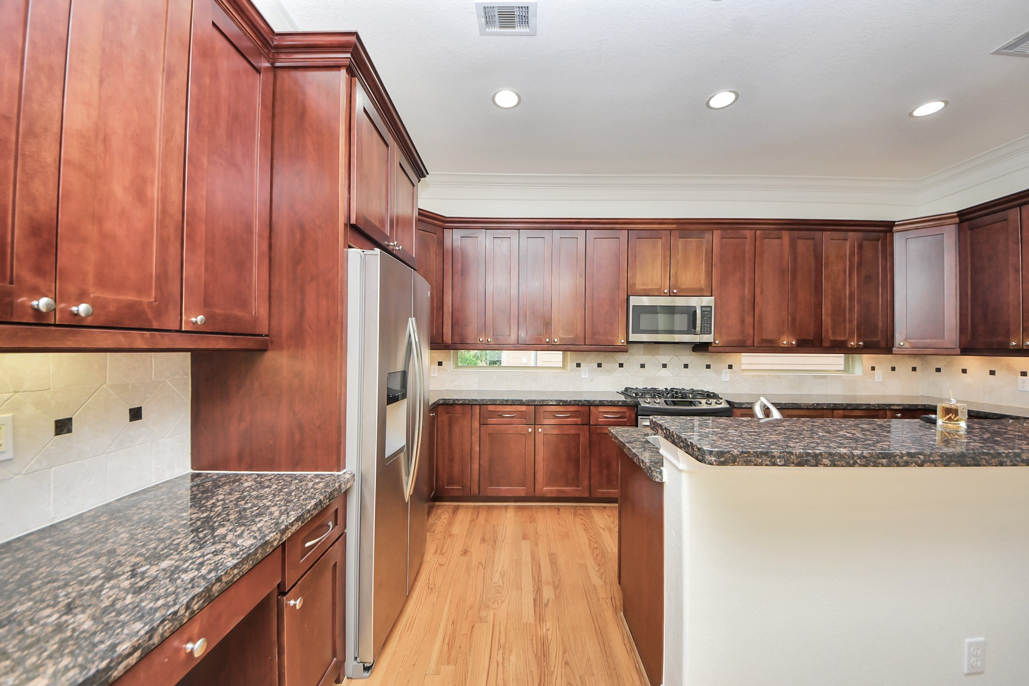 5526 Crooms Street Houston, TX 77007 - Photo 17 of 49 a kitchen with granite countertop stainless steel appliances a stove a sink and a microwave