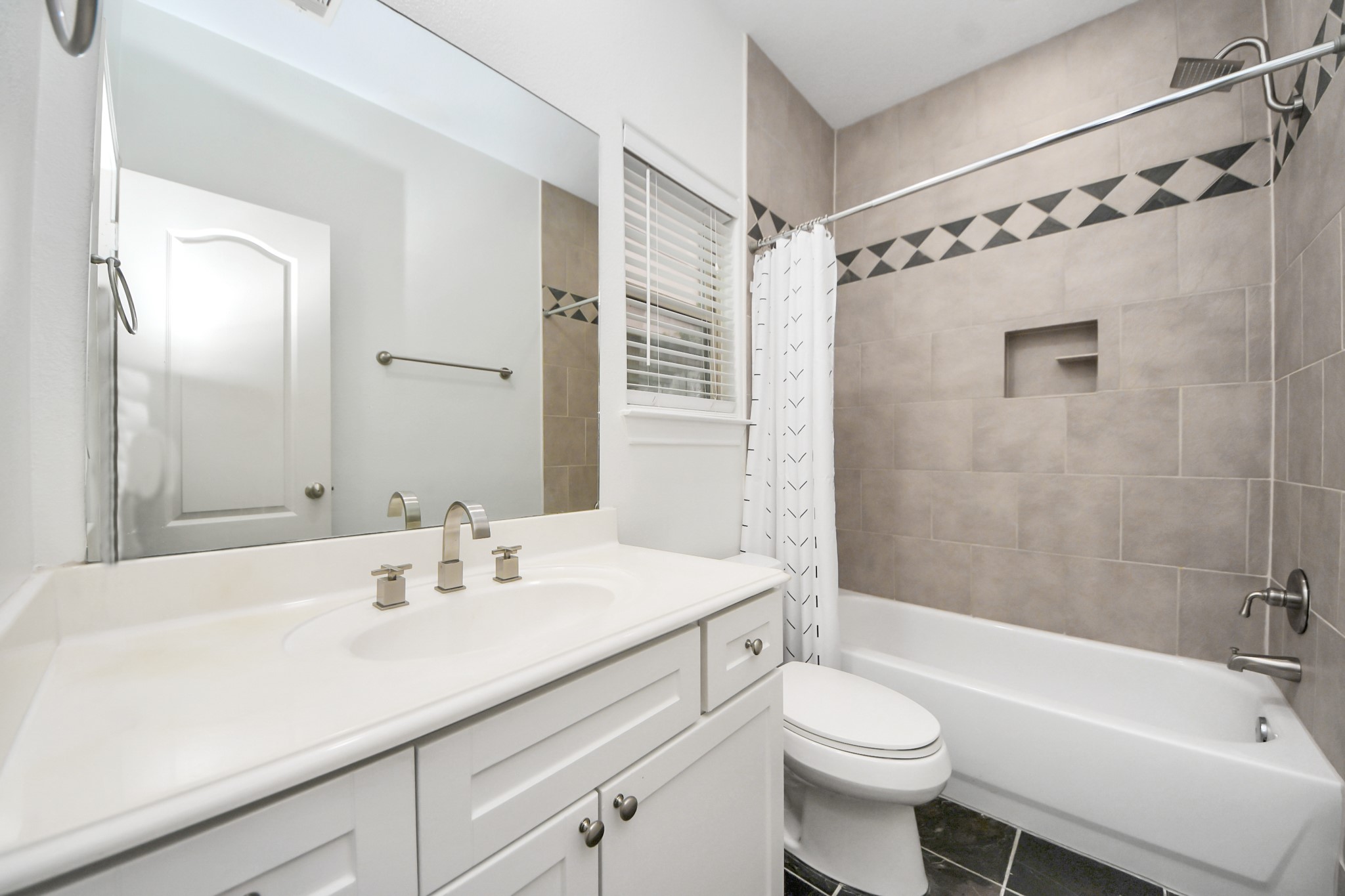 5526 Crooms Street Houston, TX 77007 - Photo 47 of 49 a bathroom with a sink a toilet a mirror a bathtub and shower