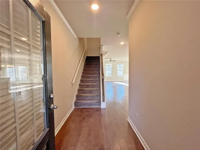 a view of a hallway with wooden floor and staircase