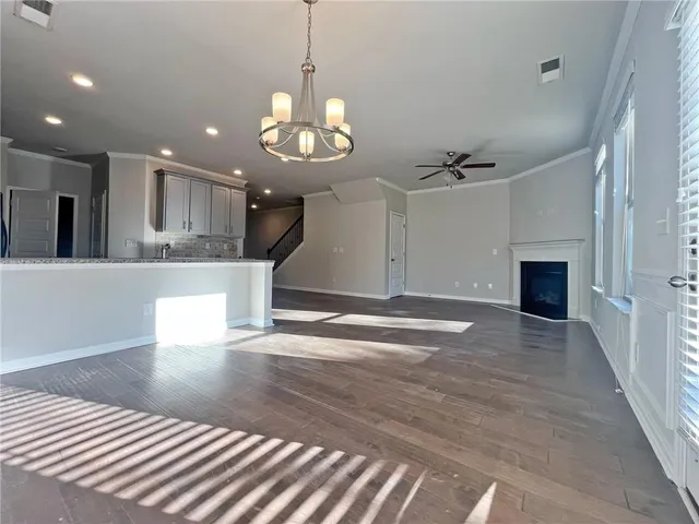 a view of a room with a ceiling fan kitchen view and a chandelier