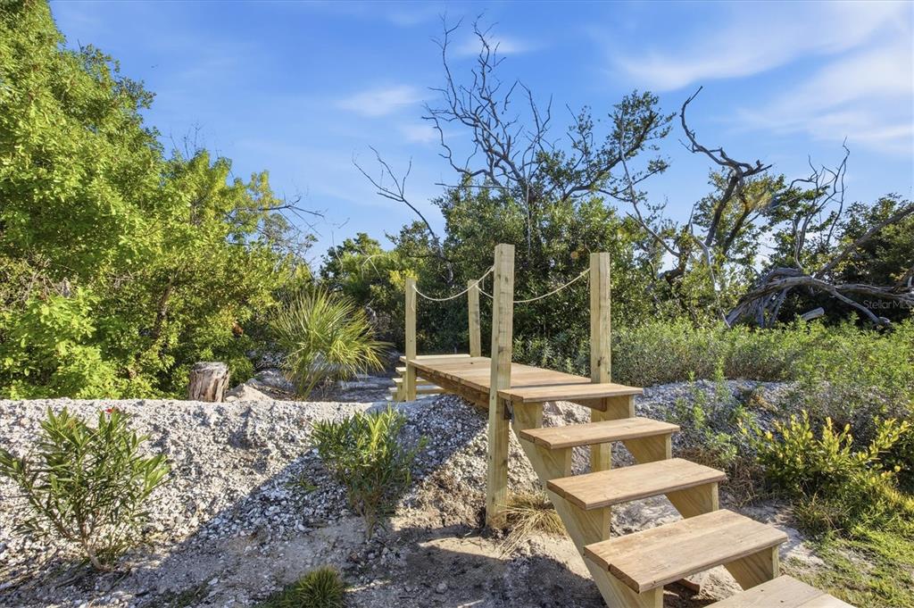 5010 Grouper Hole Court Boca Grande, FL 33921 - Photo 68 of 69 a view of a backyard with lawn chairs under a large tree