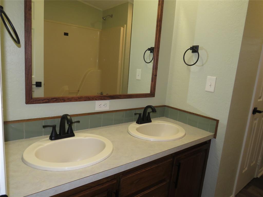 2151 Crockett Road Sanger, TX 76266 - Photo 12 of 30 a bathroom with a sink and mirror