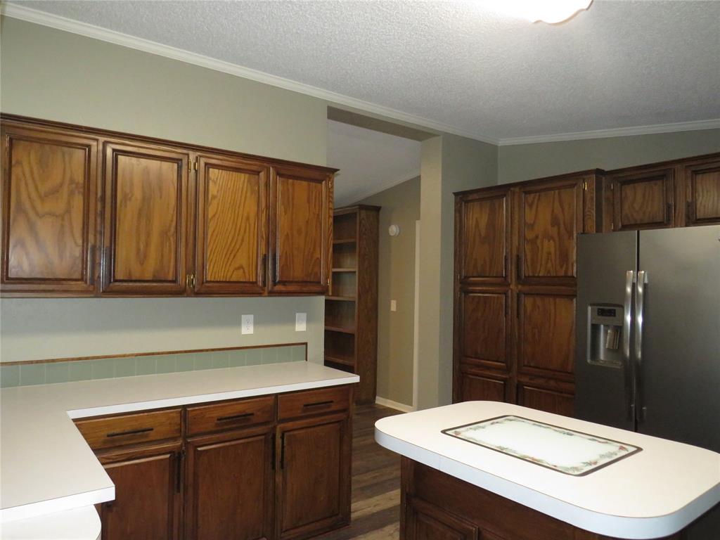 2151 Crockett Road Sanger, TX 76266 - Photo 16 of 30 a kitchen with a sink a refrigerator and cabinets