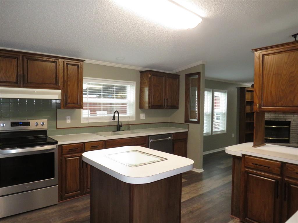 2151 Crockett Road Sanger, TX 76266 - Photo 17 of 30 a kitchen with a stove a sink and a refrigerator