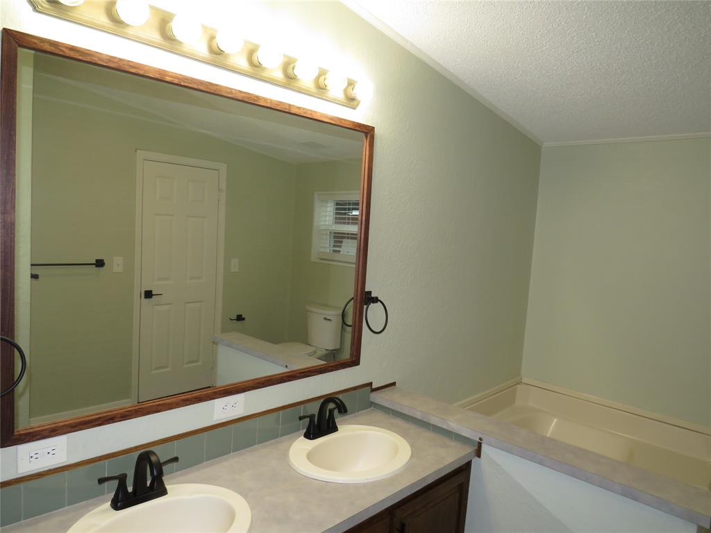 2151 Crockett Road Sanger, TX 76266 - Photo 26 of 30 a bathroom with a sink and a mirror