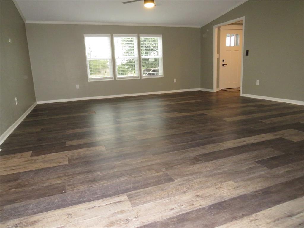 2151 Crockett Road Sanger, TX 76266 - Photo 6 of 30 an empty room with wooden floor and windows