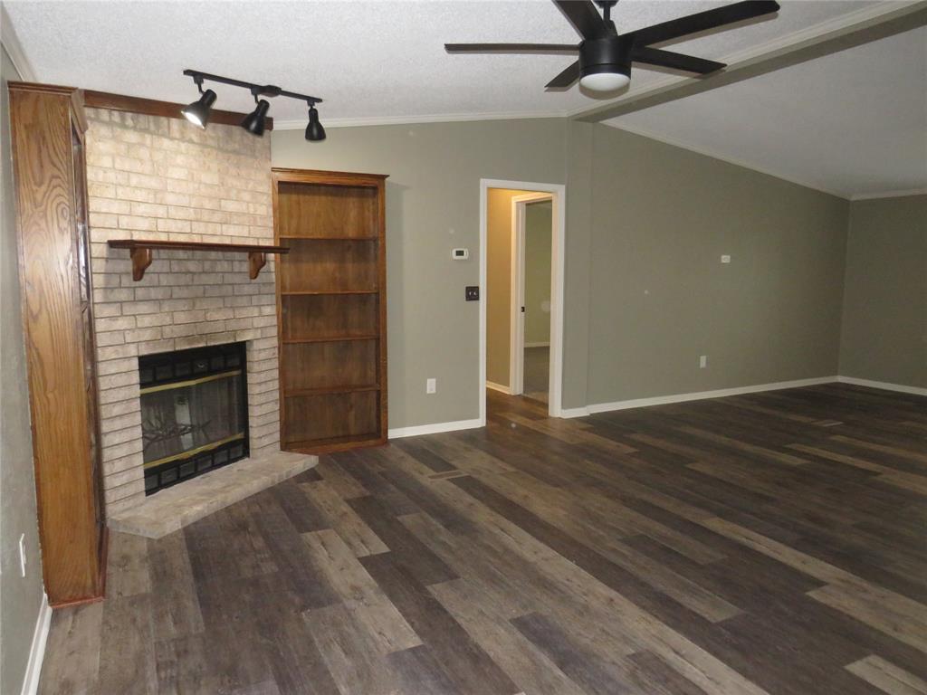 2151 Crockett Road Sanger, TX 76266 - Photo 7 of 30 a view of an empty room with wooden floor fireplace and a window