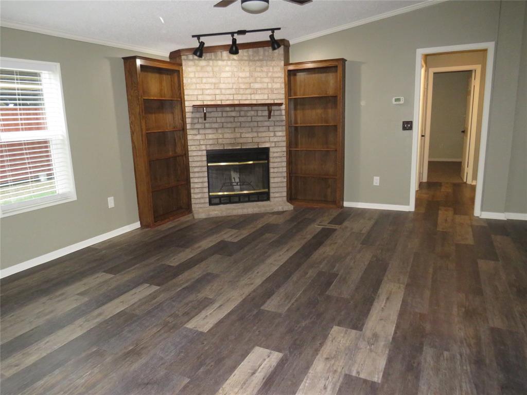 2151 Crockett Road Sanger, TX 76266 - Photo 8 of 30 a view of empty room with wooden floor and fireplace